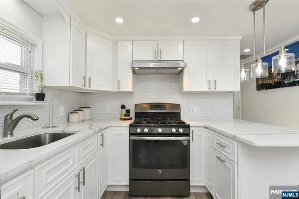 a kitchen with white cabinets and appliances