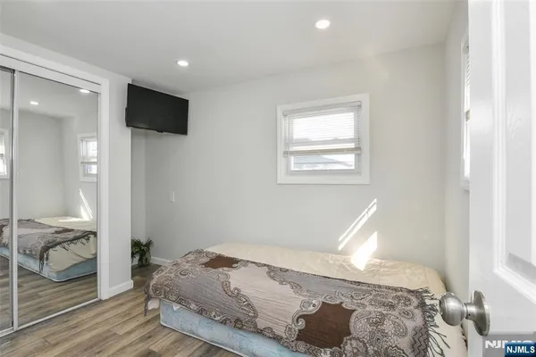 a bedroom with a bed and wooden floor