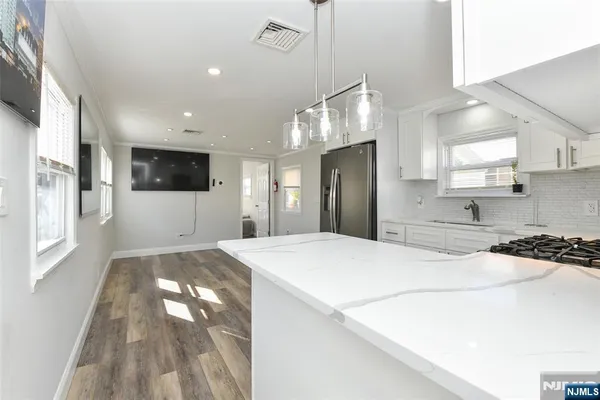 a large kitchen with stainless steel appliances kitchen island a sink stove and refrigerator