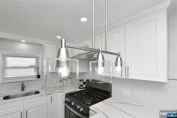 a kitchen with kitchen island a stove a sink and wooden floor