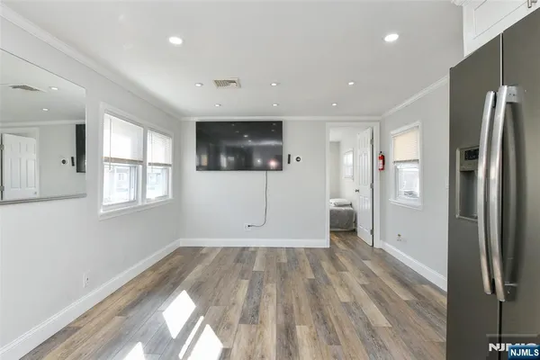 a view of wooden floor in an empty room with a window