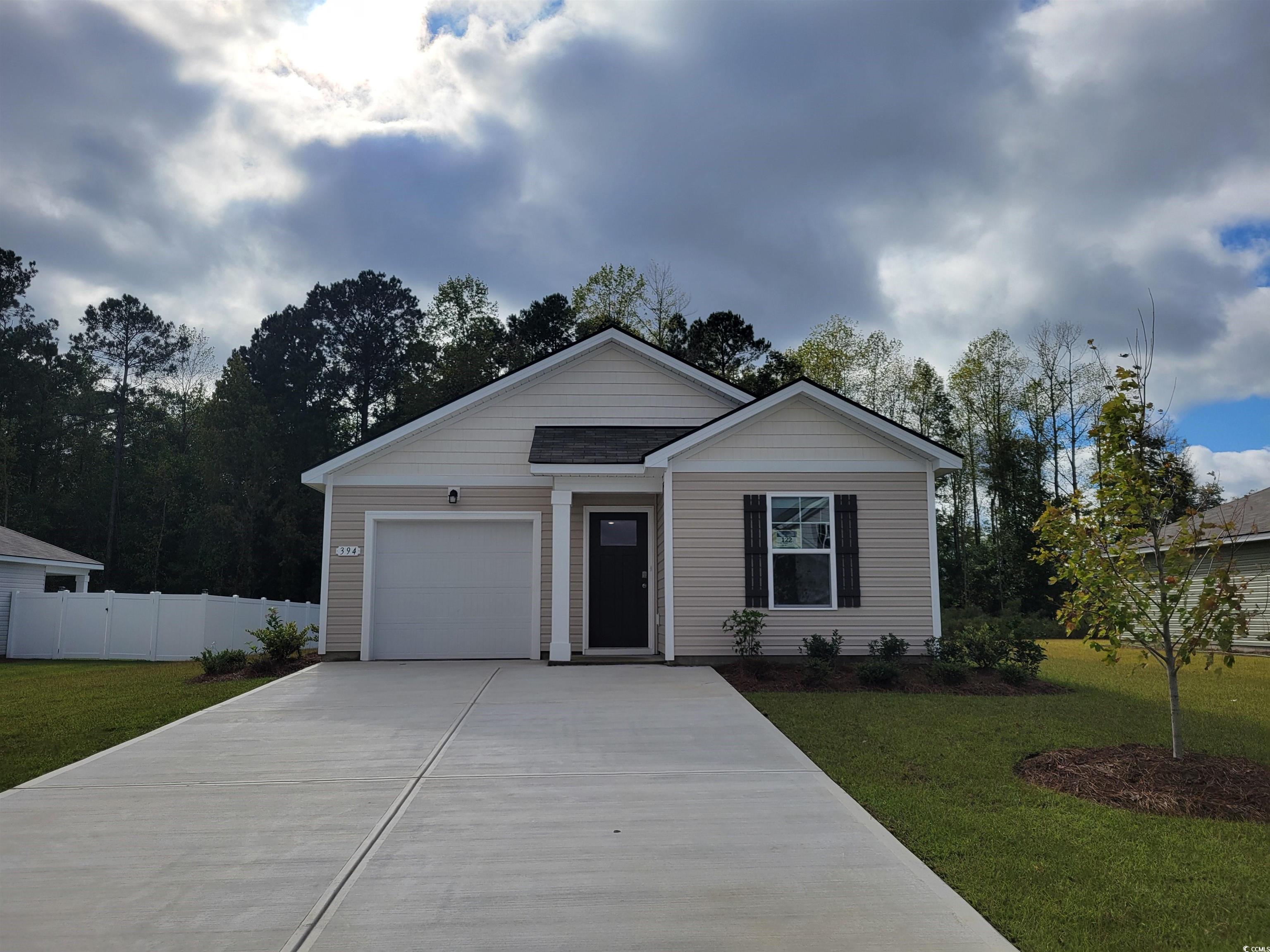 Single story home featuring concrete driveway and a garage