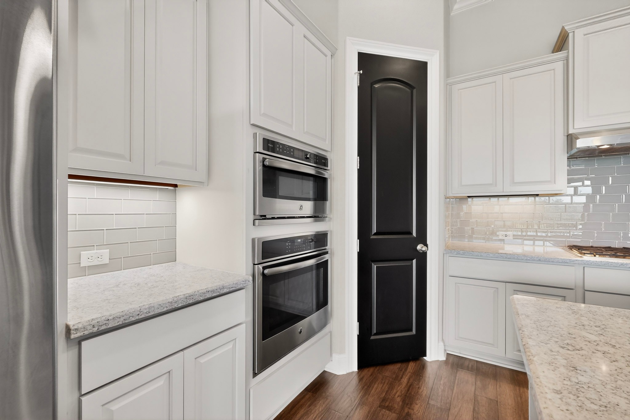 2617 Milan Meadows Drive Leander, TX 78641 - Photo 7 of 40 A contemporary kitchen features built-in stainless steel appliances and glossy subway tile.