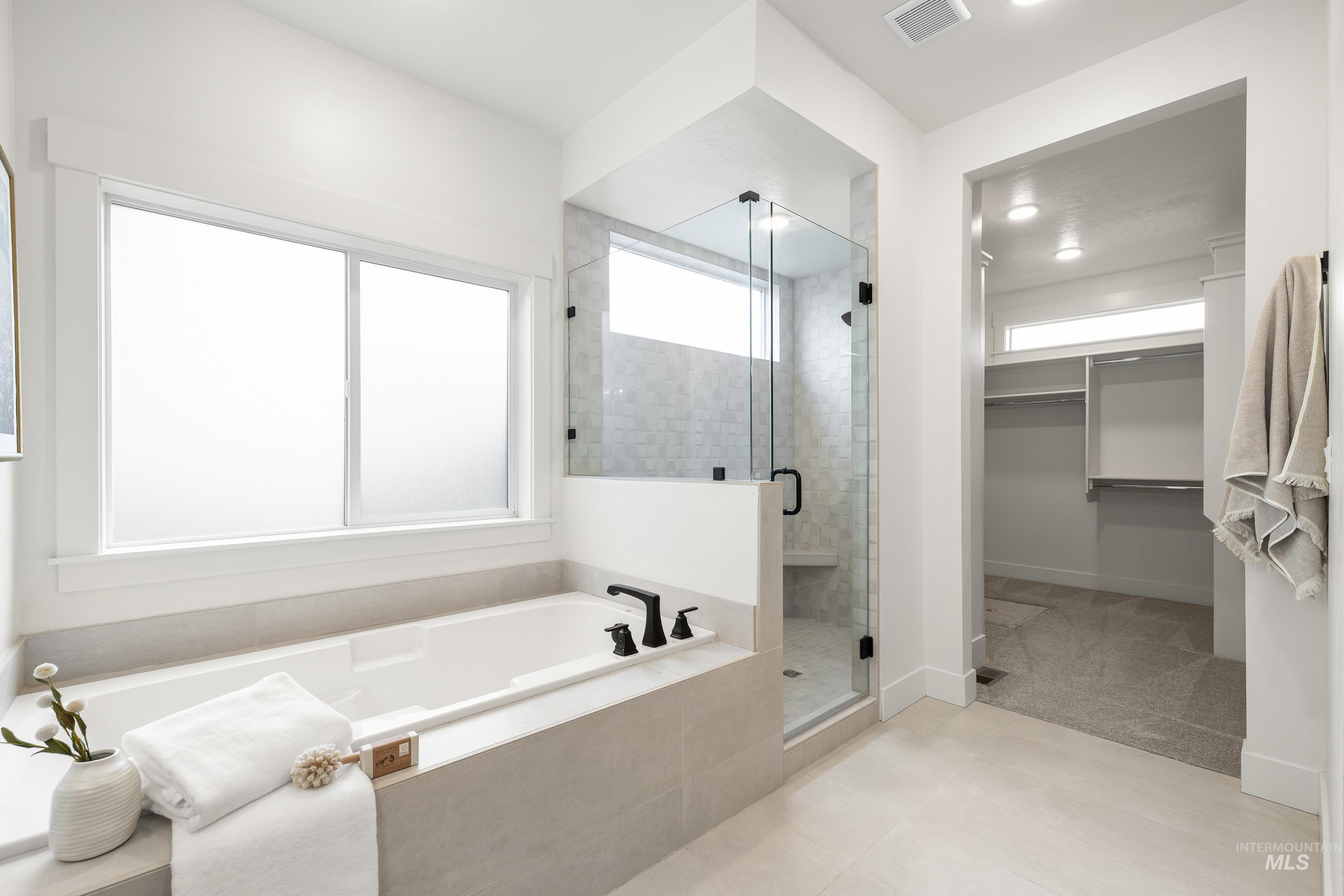 747 South Short Road Eagle, ID 83616 - Photo 27 of 48 Bathroom featuring a walk in closet, a shower stall, a garden tub, and light tile patterned flooring