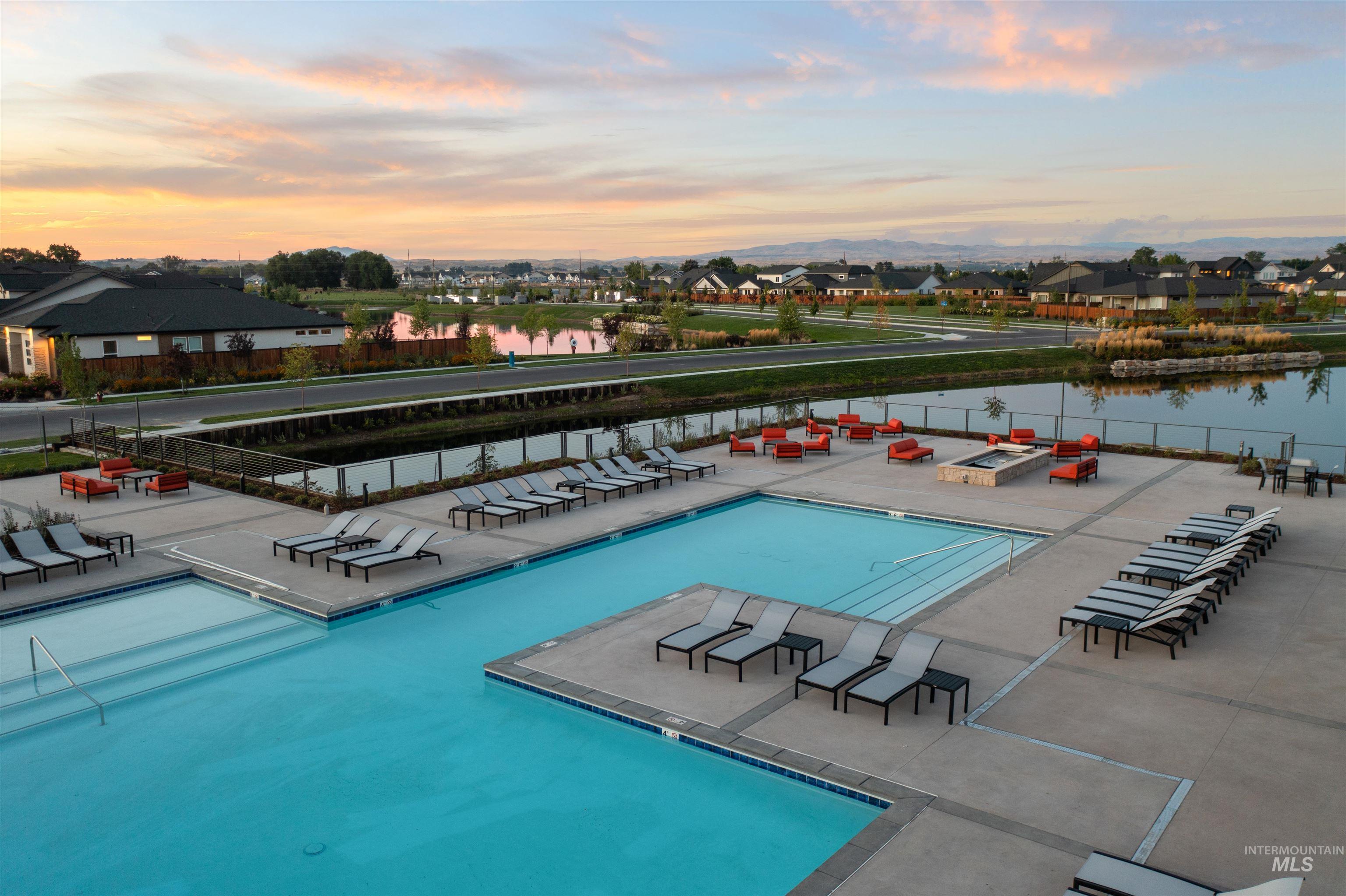 747 South Short Road Eagle, ID 83616 - Photo 46 of 48 Expansive outdoor pool deck featuring multiple swimming pools, extensive lounge seating, a central fire pit area, and waterfront views