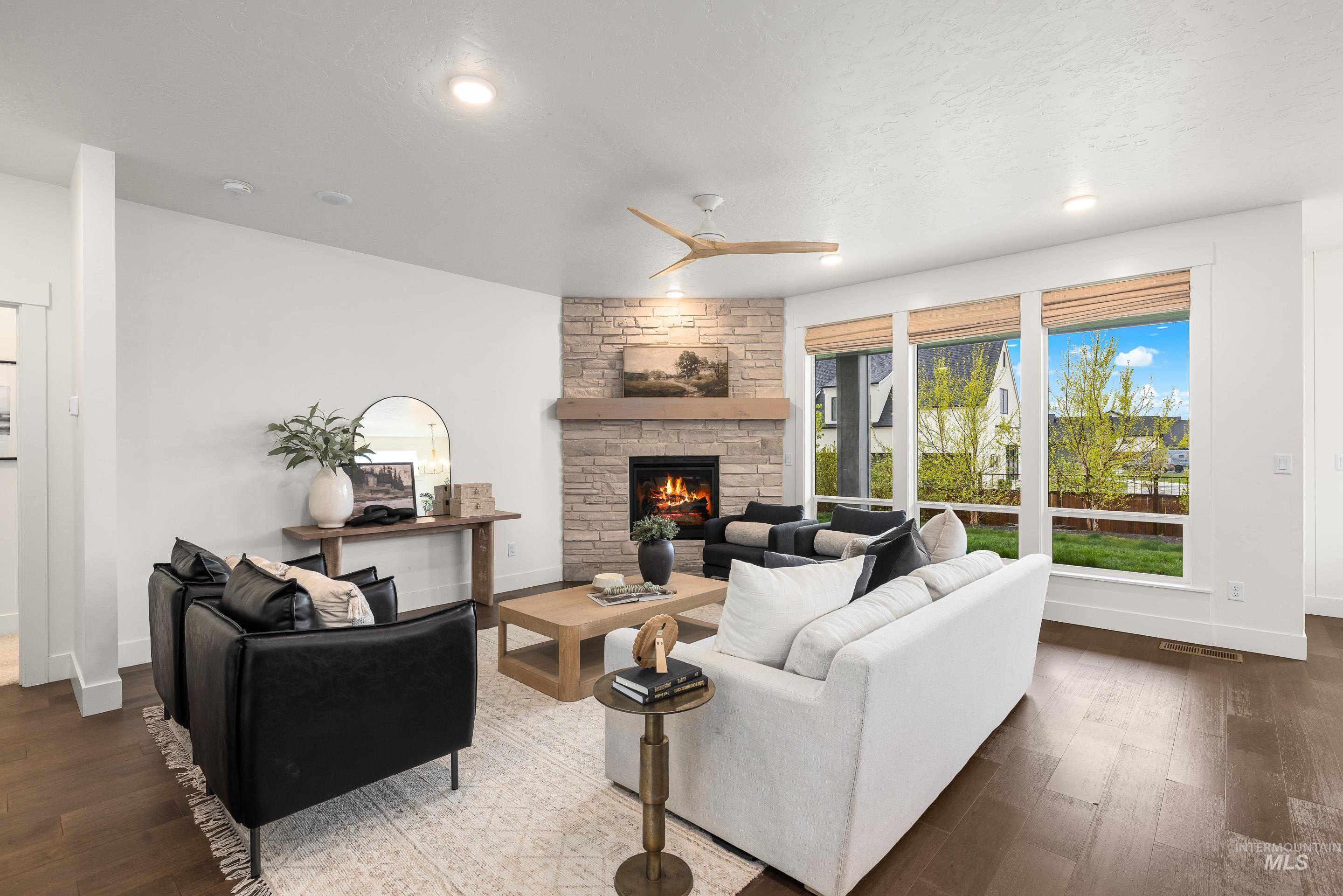 747 South Short Road Eagle, ID 83616 - Photo 5 of 48 Living room with a ceiling fan, a stone fireplace, and dark wood finished floors