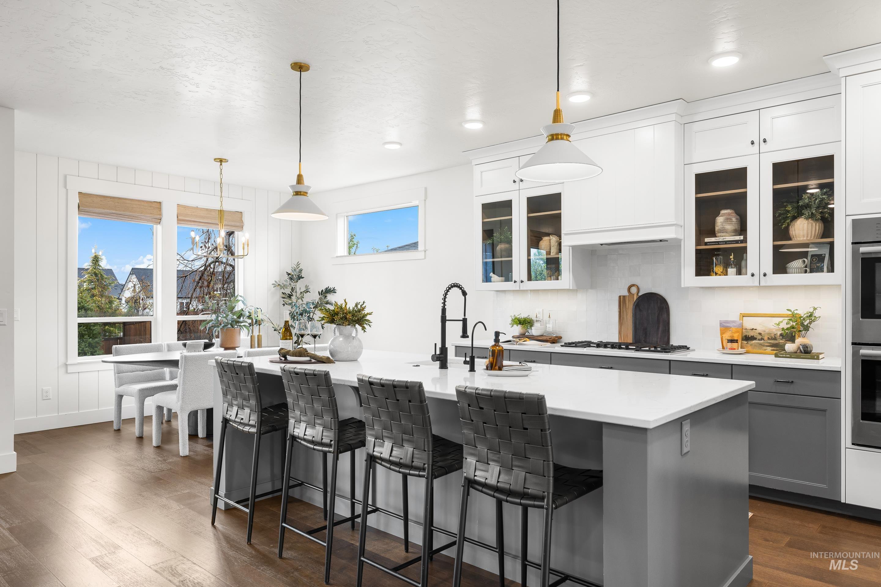 747 South Short Road Eagle, ID 83616 - Photo 10 of 48 Kitchen with decorative light fixtures, dark wood-style flooring, a kitchen breakfast bar, an island with sink, and two tone color scheme