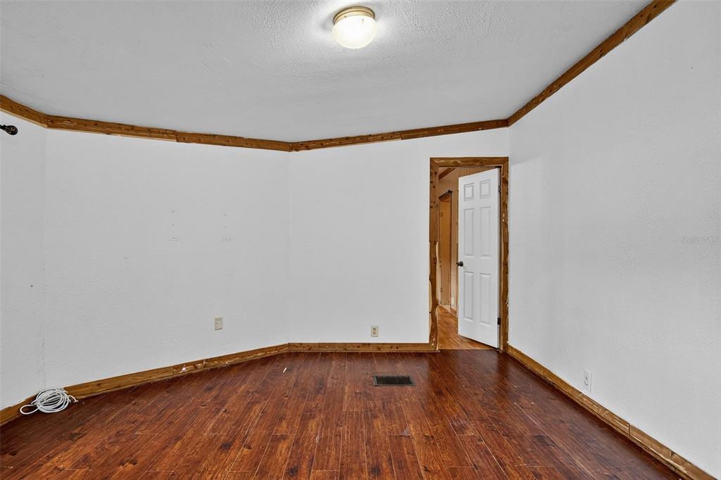 156 Kingfish Road Pomona Park, FL 32181 - Photo 17 of 55 a view of an empty room with wooden floor and a window