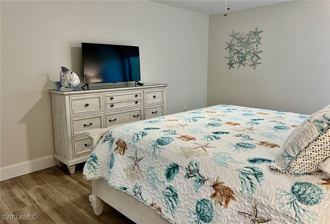 5117 Sea Bell Road, Unit F104 Sanibel, FL 33957 - Photo 17 of 41 a bedroom with a bed and a flat screen tv