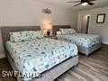 5117 Sea Bell Road, Unit F104 Sanibel, FL 33957 - Photo 23 of 41 a bedroom with a bed and a mirror