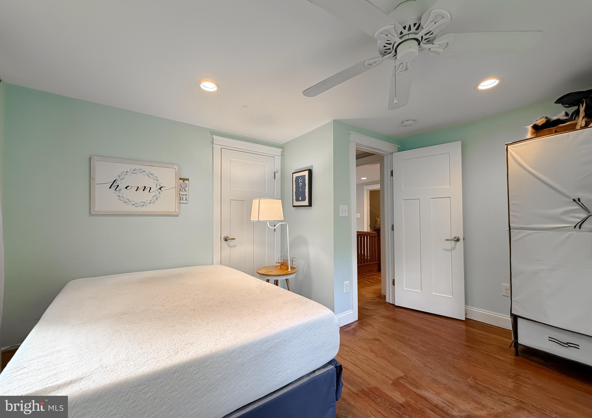 16146 Thomas Road Piney Point, MD 20674 - Photo 26 of 57 a bedroom with a large bed and a chandelier