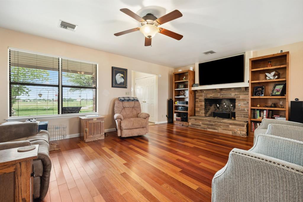 2752 South Branch Road Krum, TX 76249 - Photo 8 of 33 a living room with furniture a flat screen tv and a fireplace