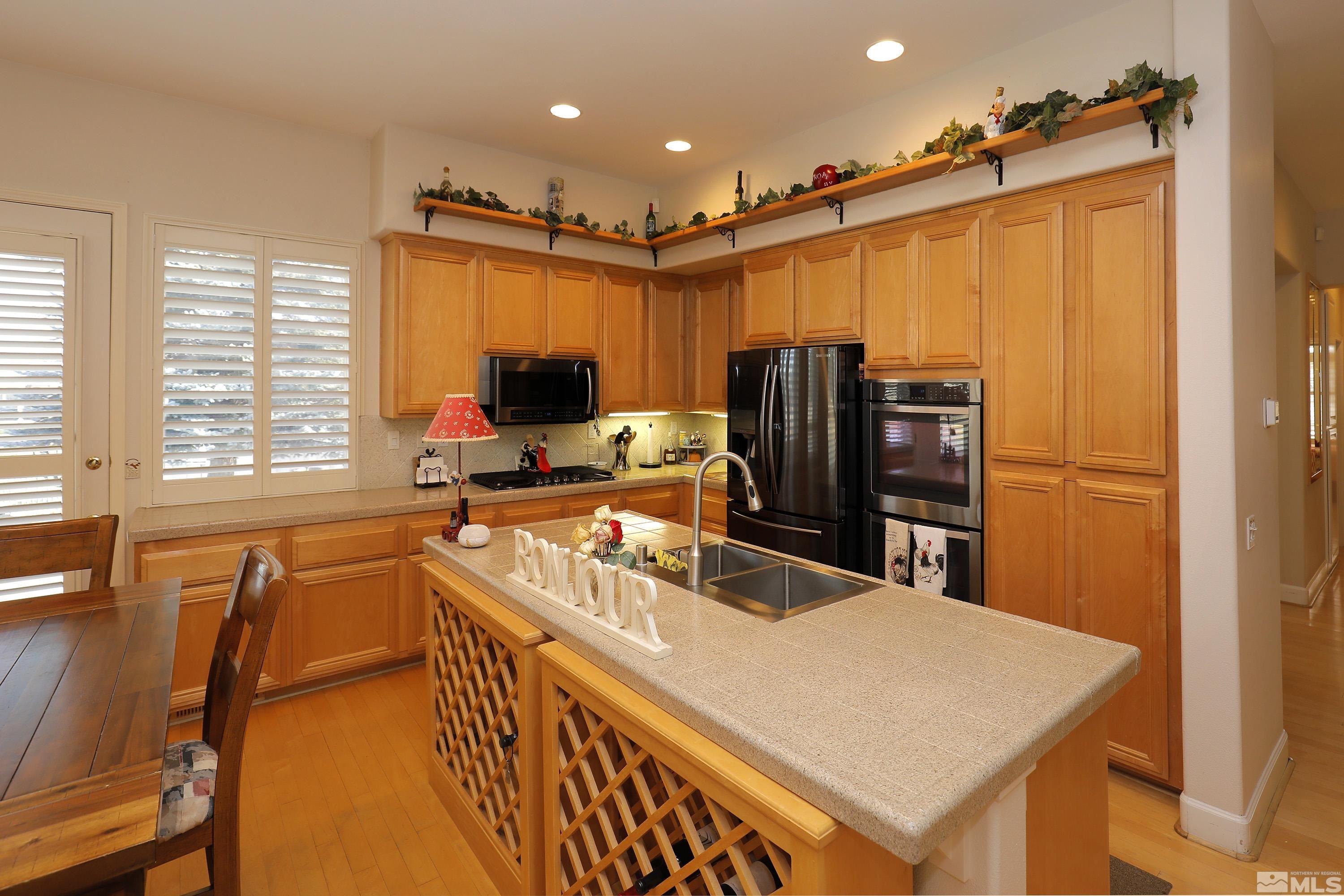 2461 Genoa Genoa, NV 89411 - Photo 16 of 35 a kitchen with stainless steel appliances a refrigerator sink and wooden cabinets