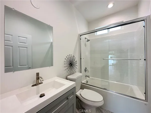 a bathroom with a sink mirror bathtub and toilet