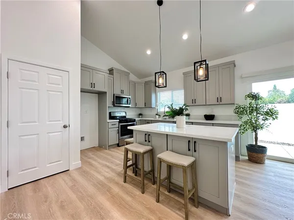 a kitchen with white cabinets and stainless steel appliances
