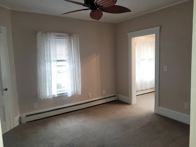 an empty room with a window and a fan