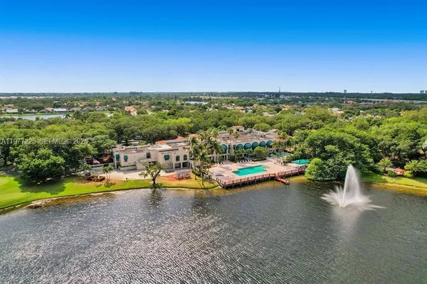 a view of a swimming pool with an ocean and trees in the background