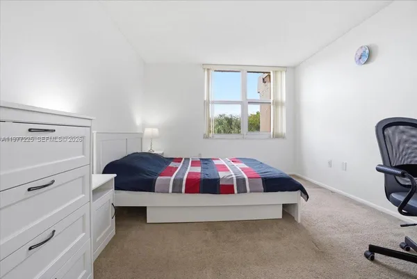 a spacious bedroom with a bed and window