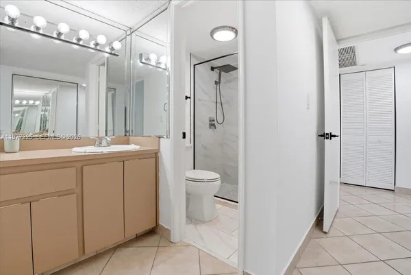 a bathroom with a granite countertop sink toilet a mirror and shower
