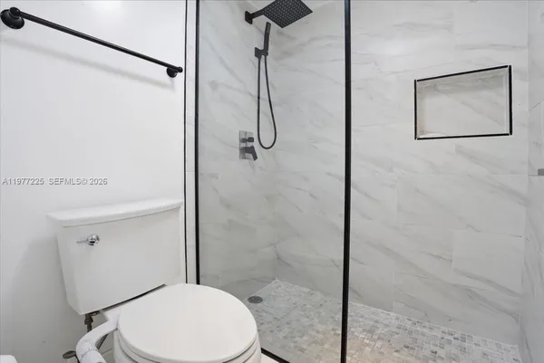 a bathroom with a toilet and a shower