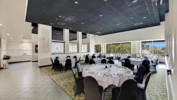 a large dining space with furniture a rug and a large window