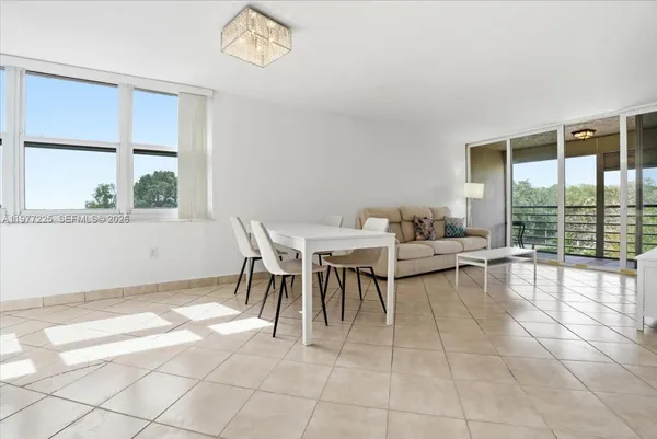 a dining room with chandelier and wooden floor