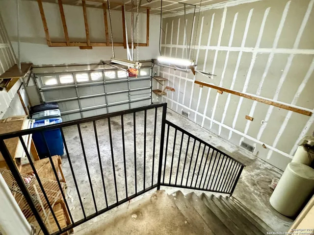 a view of a patio with table and chairs and floor to ceiling window with wooden fence