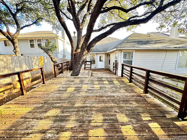 a view of a house with a small yard and a large tree