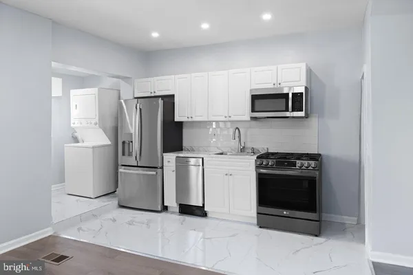 a kitchen with stainless steel appliances granite countertop a stove a refrigerator and a microwave