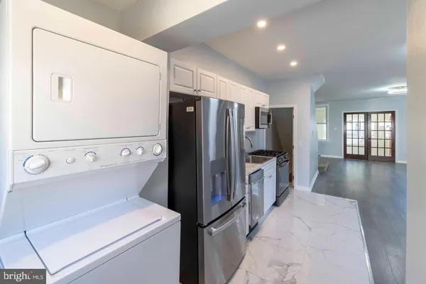 a view of a kitchen with refrigerator and wooden floor
