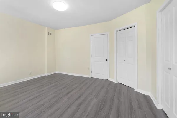 a view of an empty room with wooden floor