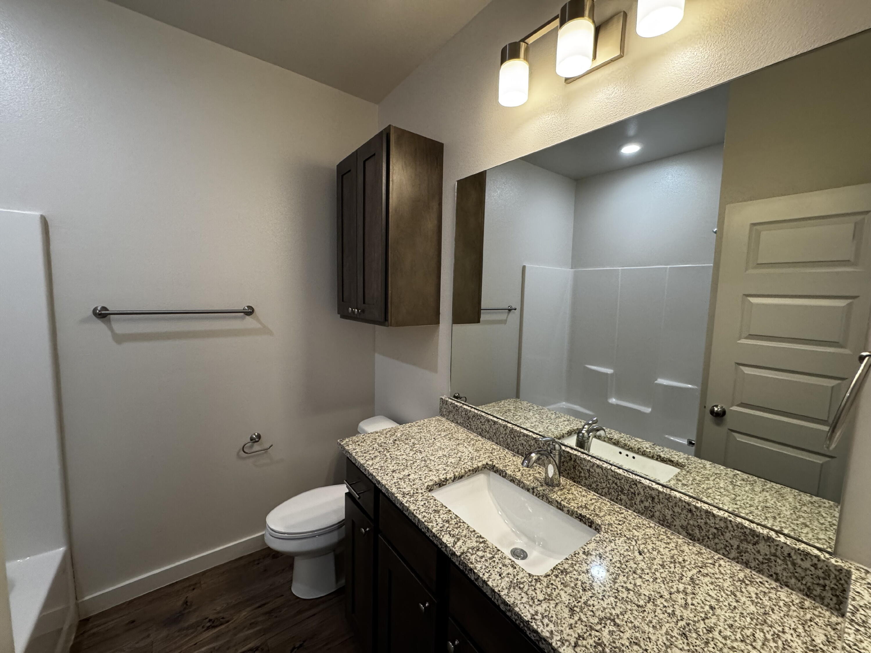 2620 135th Street Lubbock, TX 79423 - Photo 12 of 13 a bathroom with a granite countertop sink toilet and shower