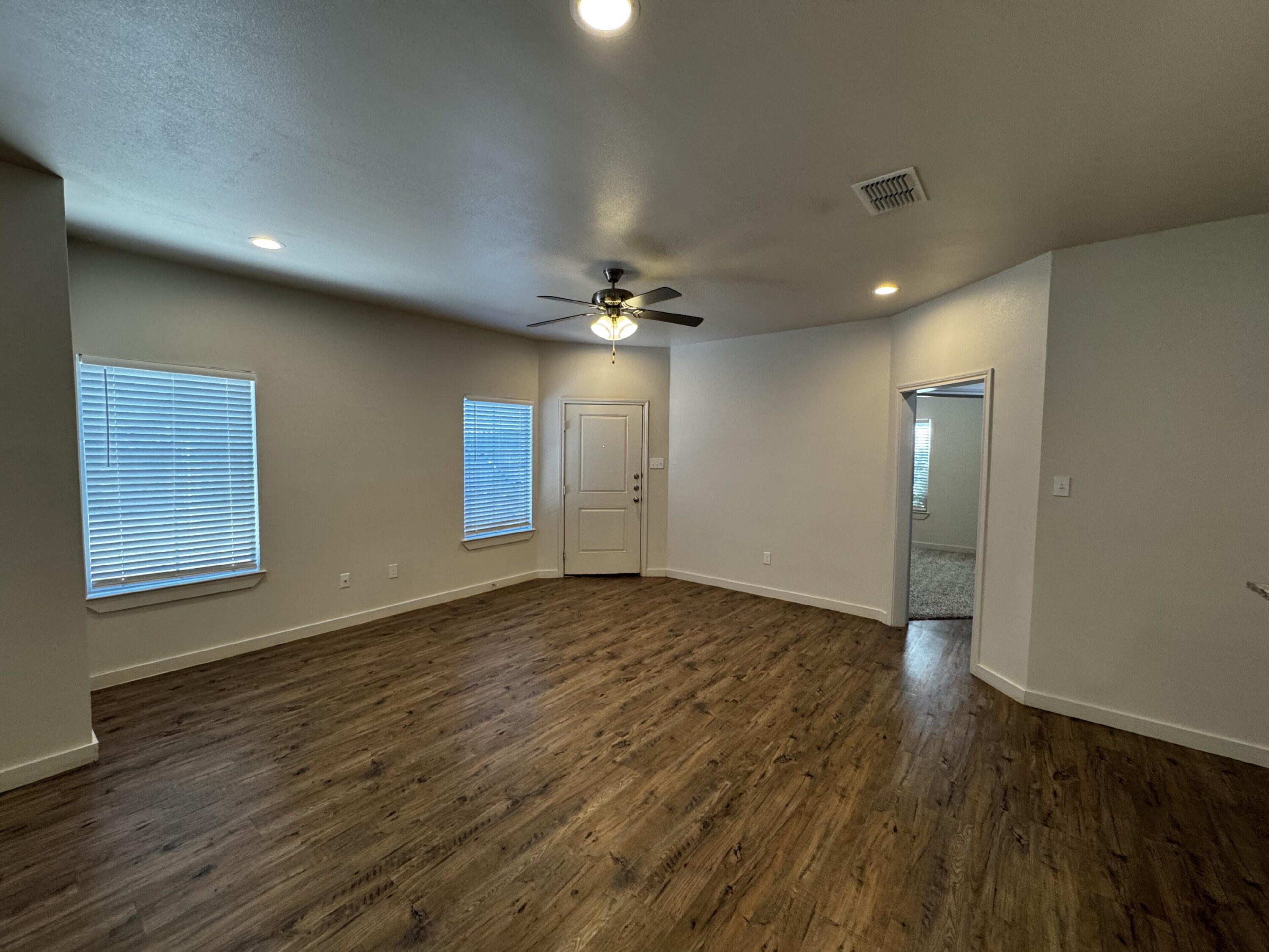 2620 135th Street Lubbock, TX 79423 - Photo 2 of 13 an empty room with wooden floor and windows