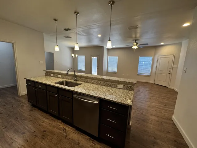 a large kitchen with a sink a refrigerator and a stove