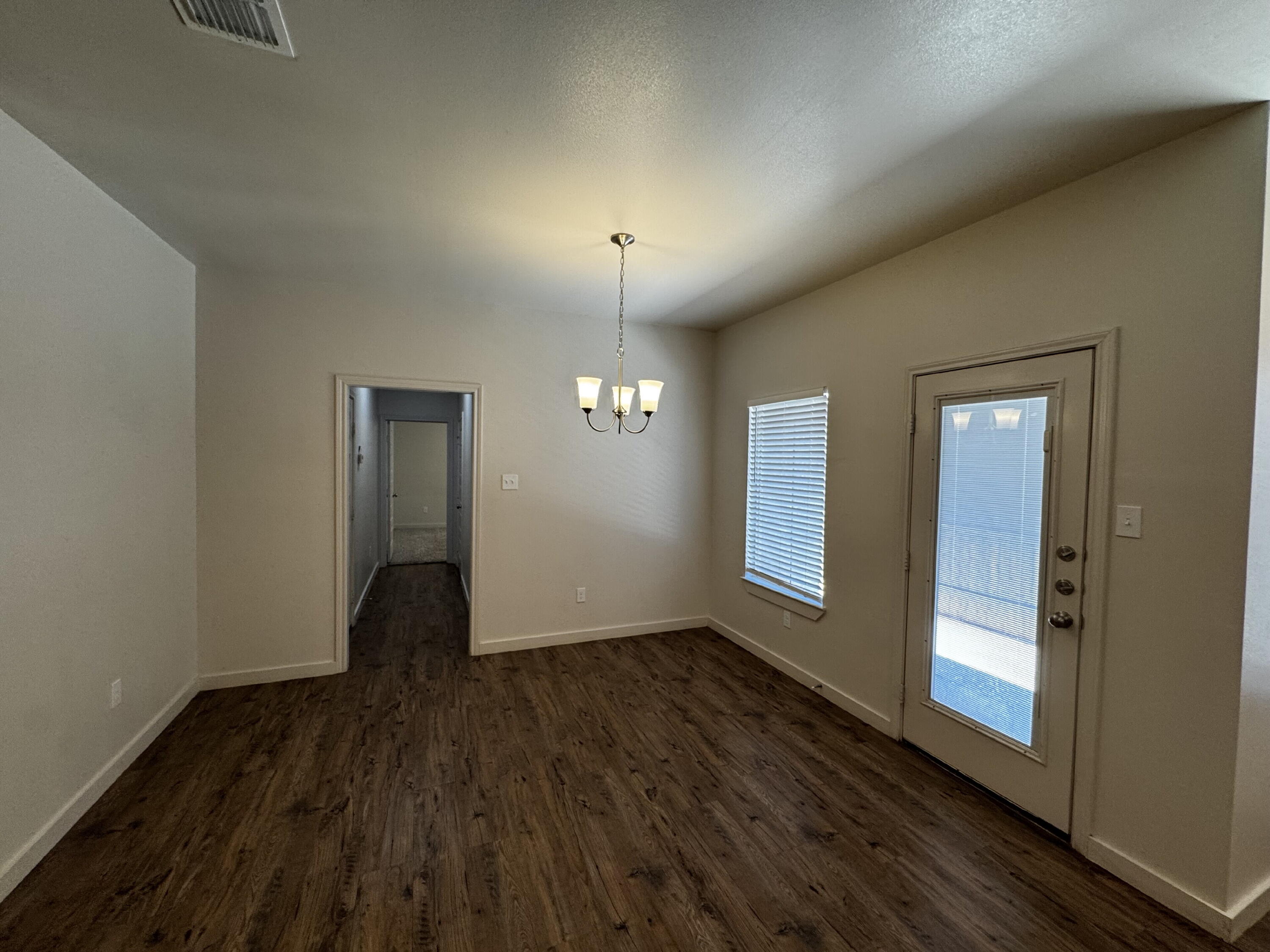 2620 135th Street Lubbock, TX 79423 - Photo 6 of 13 an empty room with wooden floor and windows
