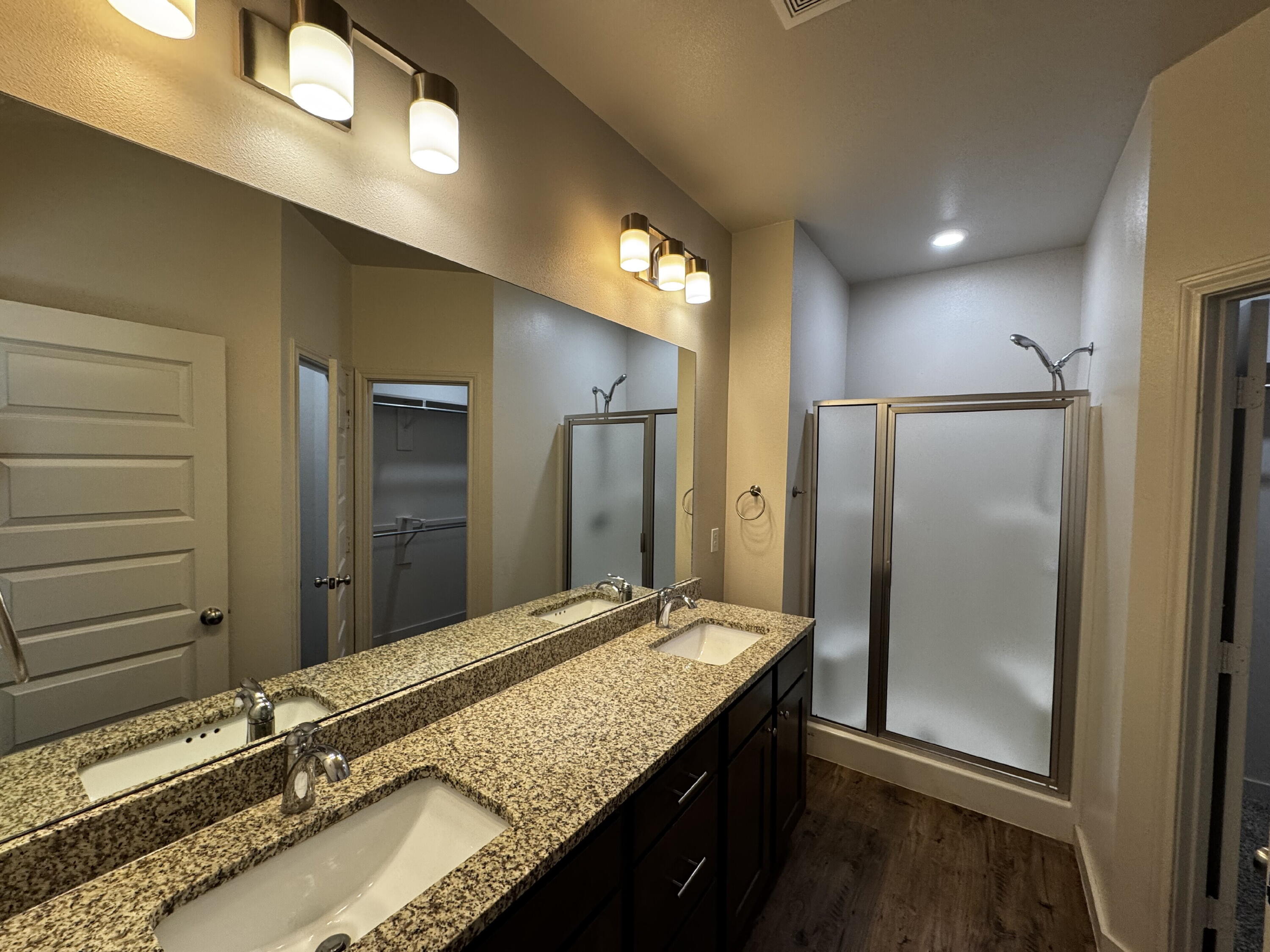 2620 135th Street Lubbock, TX 79423 - Photo 9 of 13 a bathroom with a granite countertop sink and a large mirror