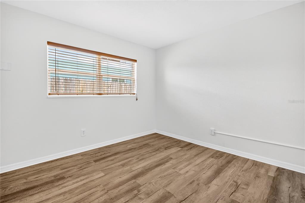 13440 1st Street East Madeira Beach, FL 33708 - Photo 38 of 44 a view of an empty room with wooden floor and a window
