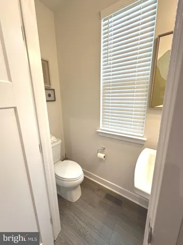 a view of a hallway with wooden floor and a living room