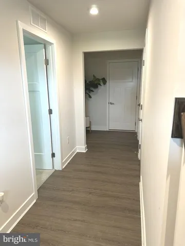 a view of a hallway with wooden floor and closet