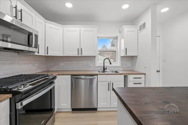 a kitchen with stainless steel appliances a sink stove and cabinets