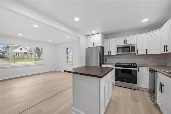 a kitchen with stainless steel appliances granite countertop a stove a sink and a refrigerator