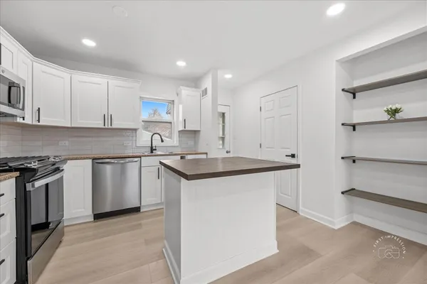 a kitchen with stainless steel appliances granite countertop a sink stove and cabinets