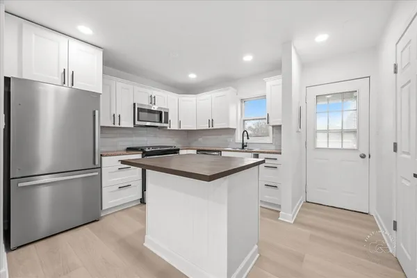 a kitchen with stainless steel appliances granite countertop a refrigerator a stove a sink and a refrigerator