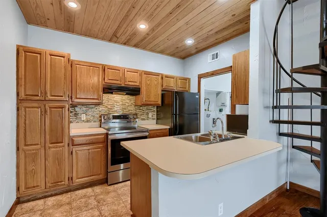 a kitchen with stainless steel appliances a refrigerator and a stove top oven