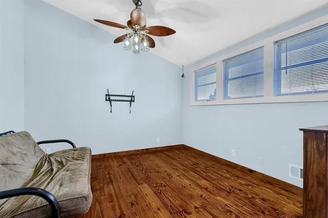 a view of a room with wooden floor and ceiling fan