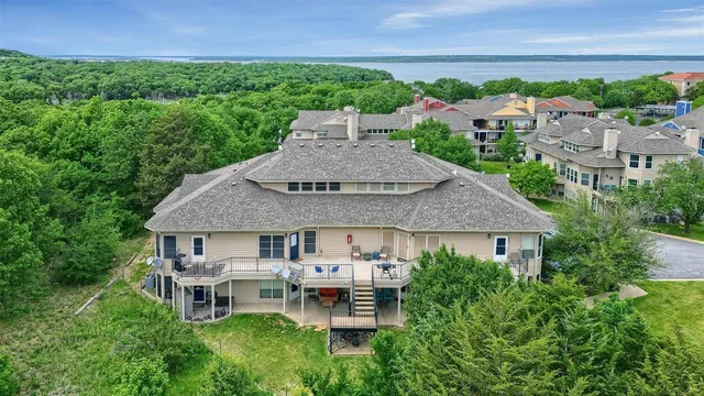 an aerial view of a house with a yard and lake view