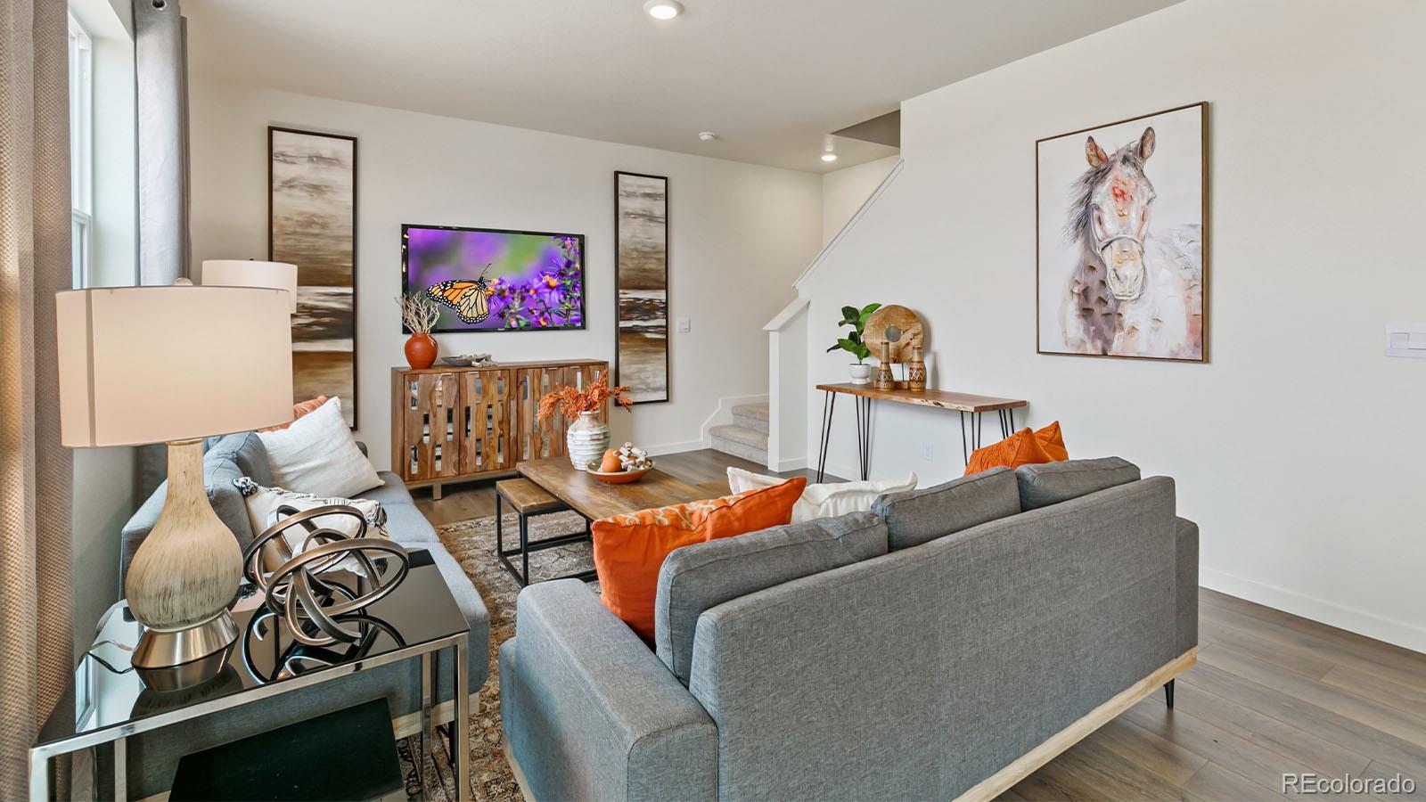 801 South Apex Avenue Fort Lupton, CO 80621 - Photo 12 of 26 a living room with furniture and a flat screen tv