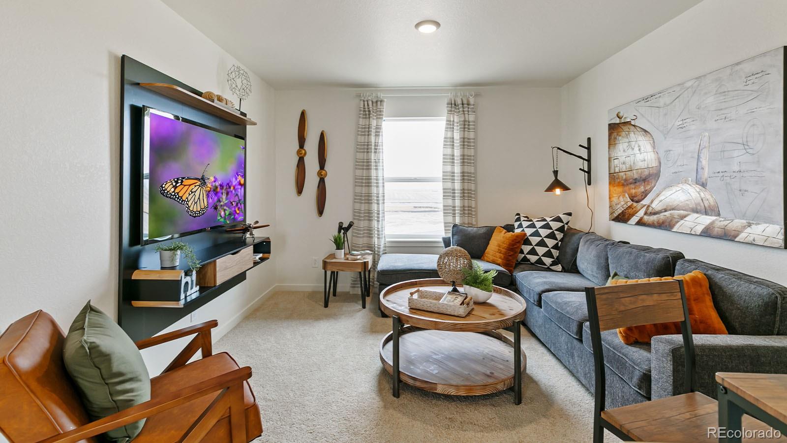 801 South Apex Avenue Fort Lupton, CO 80621 - Photo 16 of 26 a living room with furniture and a flat screen tv