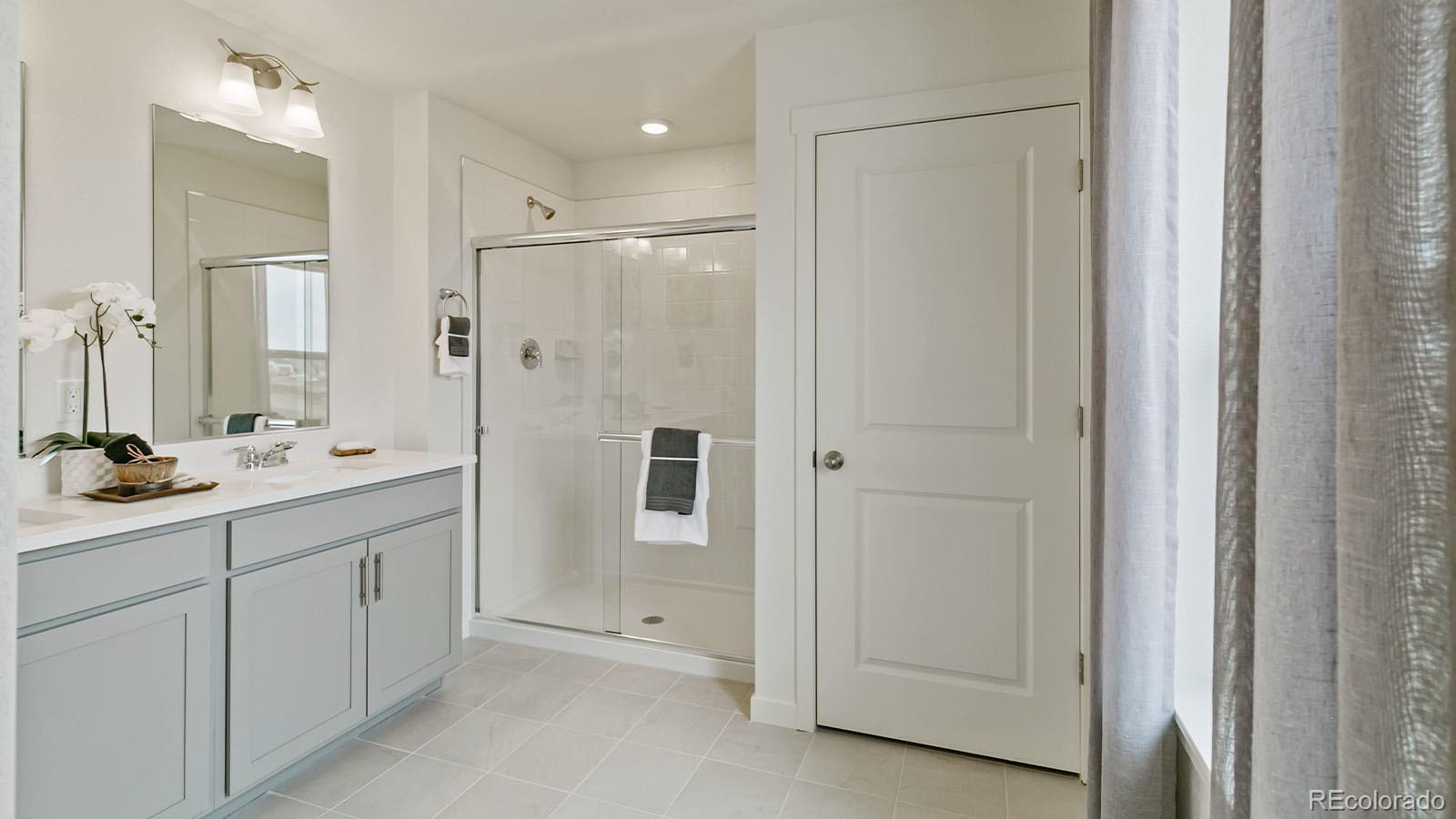 801 South Apex Avenue Fort Lupton, CO 80621 - Photo 21 of 26 a bathroom with a shower sink and mirror