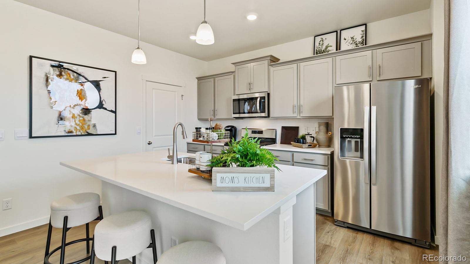 801 South Apex Avenue Fort Lupton, CO 80621 - Photo 8 of 26 a kitchen with a refrigerator and a sink